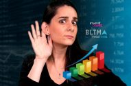 Mulher atenta, com mão na orelha, ouvindo dados de mercado financeiro com gráficos e "investnews" ao fundo.