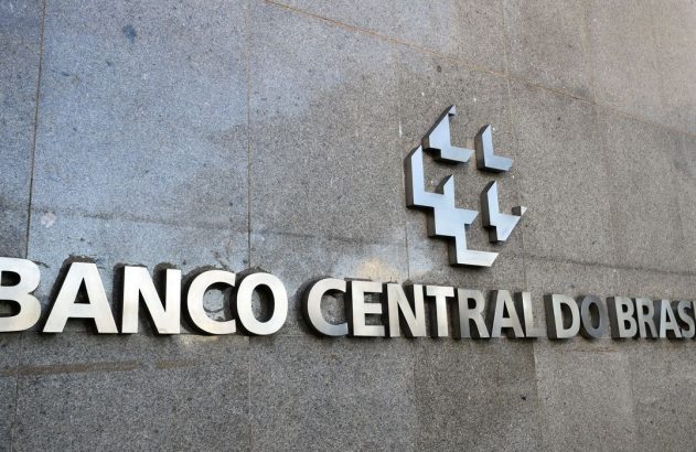 Sinalização metálica do Banco Central do Brasil com logo na parede de pedra.