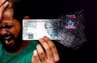 Pessoa negra com mão na testa e uma nota de cem reais na outra mão