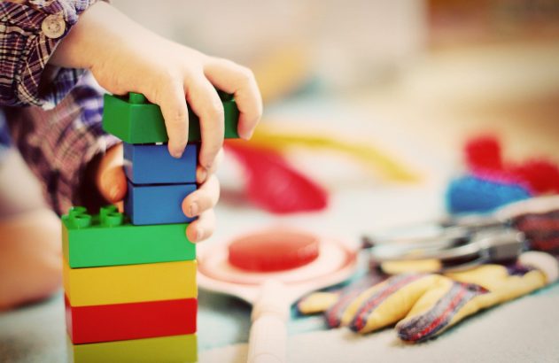 mão de uma criança com peças de Lego