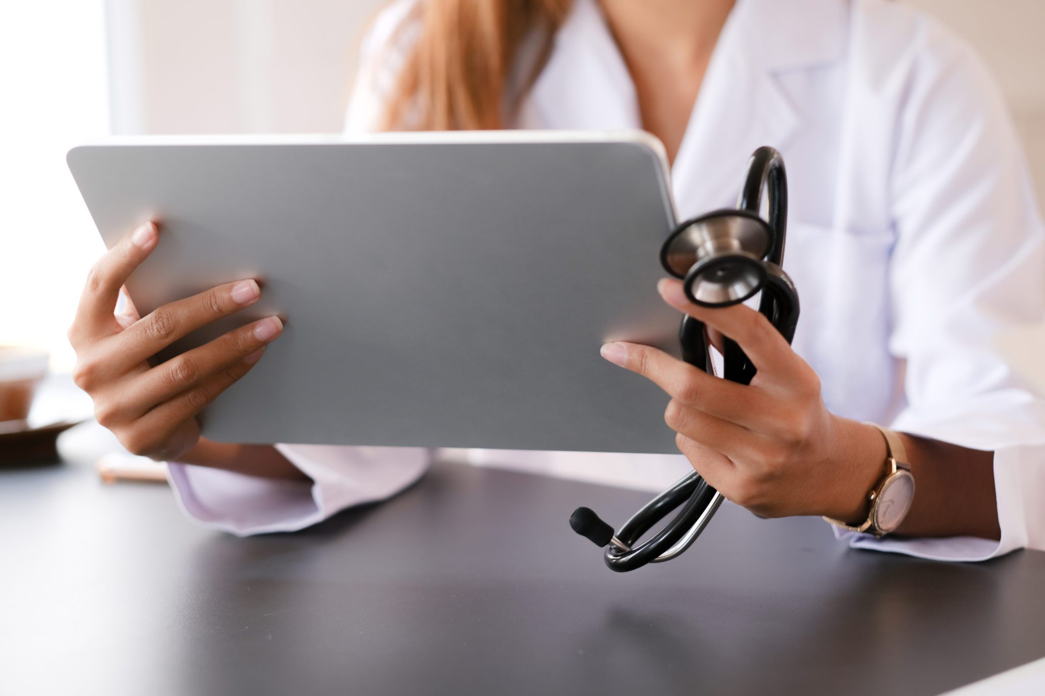 Médico segura um tablet enquanto trabalha