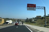 Rodovia com tráfego lento e letreiro da CCR NovaDutra: "BEM-VINDO - TRECHO SOB CONCESSÃO".