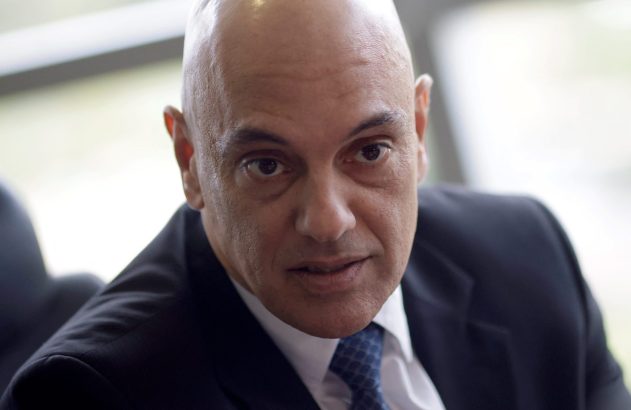 Retrato de homem careca, de terno e gravata, olhando seriamente para a câmera.