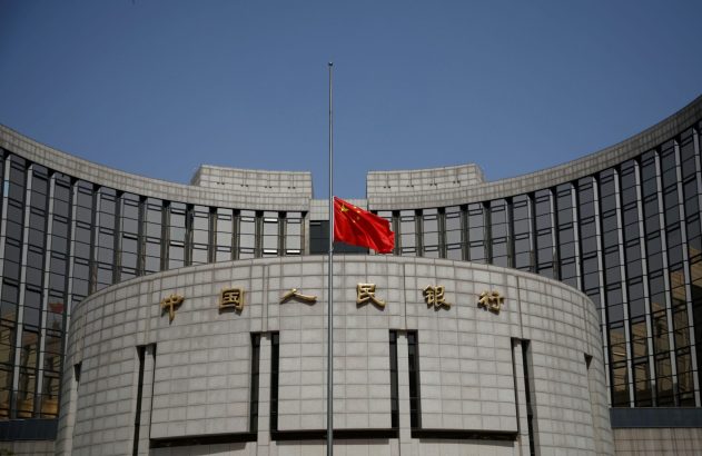 Bandeira da China a meio mastro em frente ao edifício do Banco Popular da China.