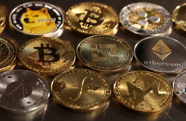 Várias moedas físicas de criptomoedas (Bitcoin, Dogecoin, Ethereum) em tons de ouro e prata.