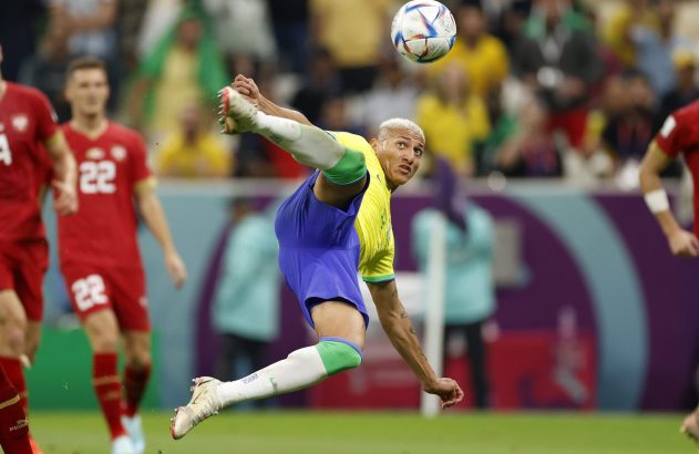Richarlison, jogador do Brasil, em chute de bicicleta, acertando a bola no ar.