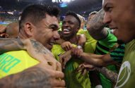 Jogadores da seleção brasileira, incluindo Vini Jr. e Casemiro, celebrando e sorrindo abraçados em campo.
