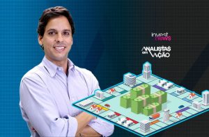 Homem sorridente com tabuleiro de jogo sobre investimentos e logos 'Investnews' e 'Analistas em Ação'.