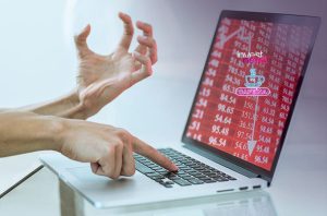 Pessoa em desespero usando laptop que exibe perdas financeiras em tela vermelha.