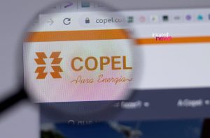 Lupa amplia tela de computador exibindo o site da Copel. O logo da empresa e o slogan "Pura Energia" estão em foco.