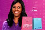 Mulher sorri. Sacolas Aliansce Sonae (rosa) e brMalls (azul). Fundo financeiro e logo InvestNews Flash.