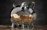 Imagem de porco em vidro com moedas douradas em seu interior
