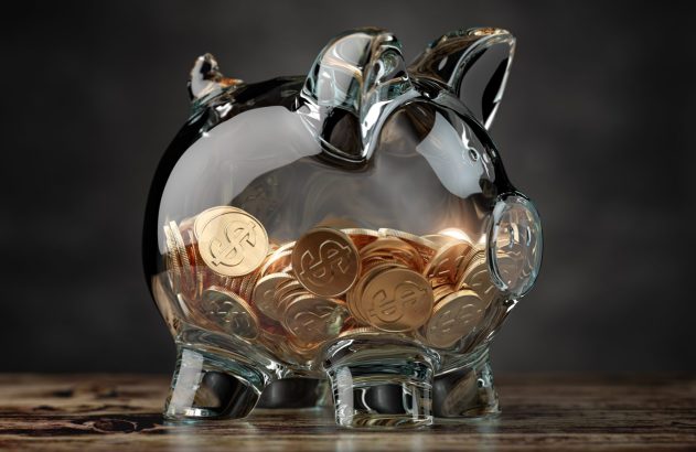 Imagem de porco em vidro com moedas douradas em seu interior