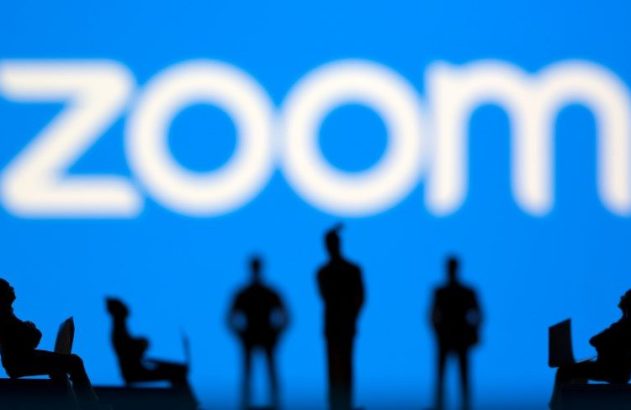 Silhuetas de pessoas, algumas com notebooks, e logo Zoom desfocado em azul.
