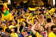 Torcida australiana animada com um canguru inflável e bandeiras erguidas em um evento.