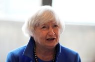 Janet Yellen, de cabelos brancos, blusa azul e colar, falando.
