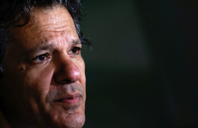 Rosto de homem de perfil, com olhar concentrado para a direita. Cabelo escuro e fundo desfocado.