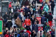Multidão de pessoas em uma rua movimentada de Nova York. Um artista vestido como Estátua da Liberdade visível.