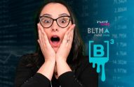 Mulher de óculos com boca aberta e mãos no rosto, em choque. Fundo digital exibe dados financeiros e logos Investnews e B3.