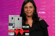 Mulher sorrindo em fundo financeiro rosa. À esquerda, eletrodomésticos (geladeira, fogão) com laço vermelho de presente.