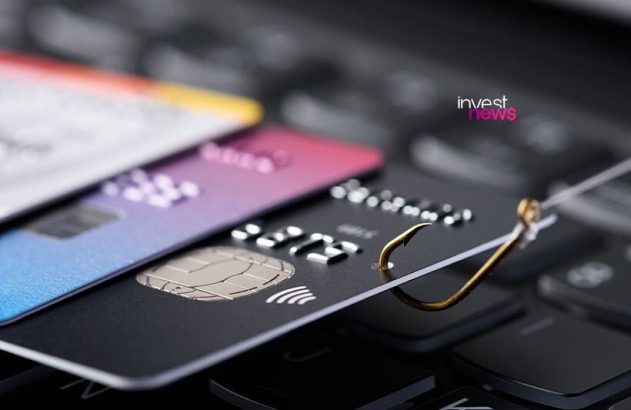 Anzol fisgando cartão de crédito em teclado, simbolizando roubo de dados ou phishing.