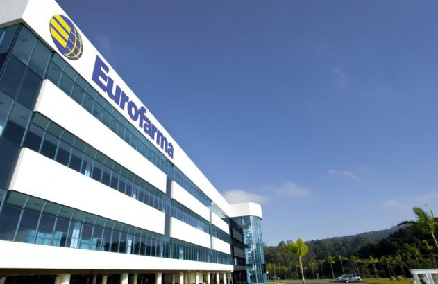 Edifício moderno da Eurofarma com logo azul e janelas de vidro sob céu claro.