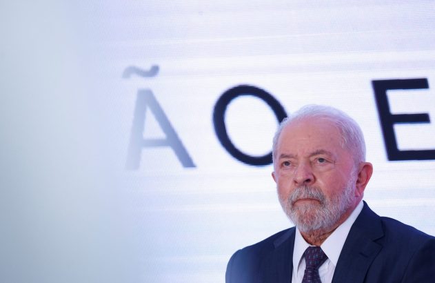 Lula, presidente do Brasil, olhando à esquerda. Fundo branco com letras grandes: Ã, O, C, E.
