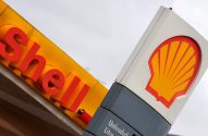 Foto de perto de placas da Shell: uma com o nome 'Shell' em vermelho, outra com o logotipo da concha.