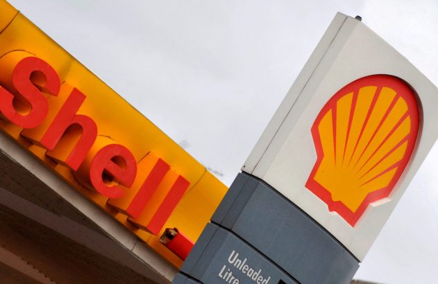 Foto de perto de placas da Shell: uma com o nome 'Shell' em vermelho, outra com o logotipo da concha.