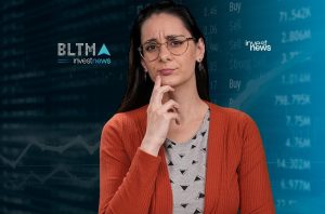 Mulher de óculos pensativa, em frente a painel de mercado financeiro. Logos "investnews".