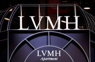 Letreiro branco LVMH em estrutura escura, com 'LVMH Apartment' na base.