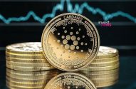 Moedas Cardano douradas empilhadas com um gráfico de mercado azul ao fundo.