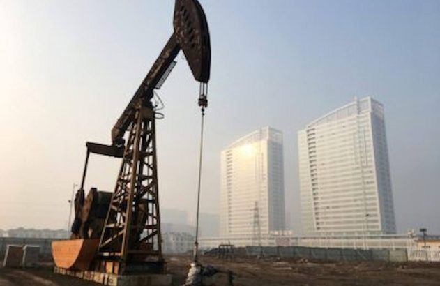 Guindaste em um terreno baldio com dois prédios ao fundo