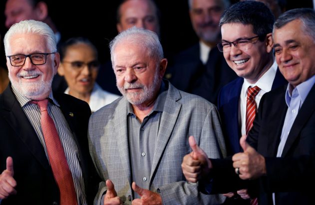 Lula e três homens sorrindo, de terno, fazem sinal de positivo.