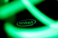 Logotipo Intel verde iluminado em fundo escuro com brilho abstrato.