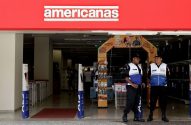 Entrada de uma loja Americanas com dois seguranças em pé na frente.
