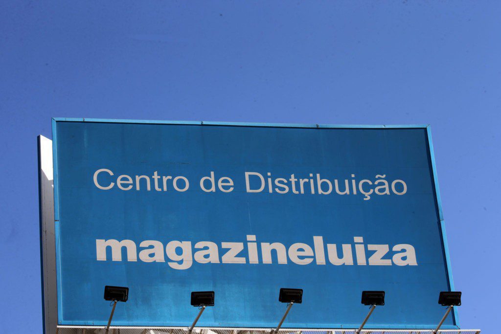 Letreiro azul "Centro de Distribuição magazineluiza" sob céu claro.