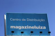 Letreiro azul "Centro de Distribuição magazineluiza" sob céu claro.