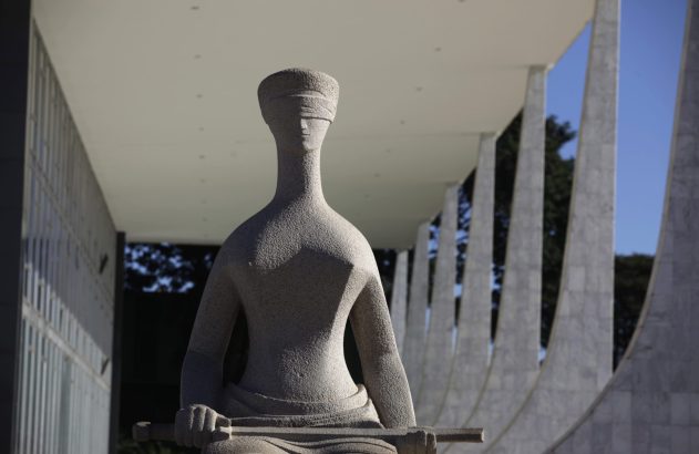 Estátua da Justiça vendada e sentada em frente ao Supremo Tribunal Federal em Brasília.