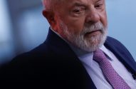 Luiz Inácio Lula da Silva, com cabelo e barba brancos, terno e gravata roxa, olhando pensativo.