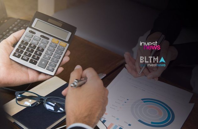 Mãos de pessoa usando calculadora e caneta sobre gráficos. Analisando dados financeiros.