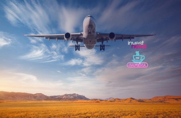 Avião decolando de um campo dourado sob um céu azul e nublado.