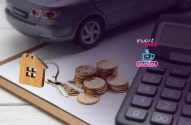 Mesa com chaves, moedas, casa, calculadora e carro desfocado. Representa finanças, patrimônio e investimentos.