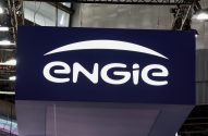 Letreiro iluminado azul escuro da Engie, com seu logo branco. Ao fundo, estruturas e luzes de evento.