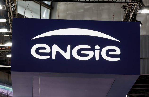 Letreiro iluminado azul escuro da Engie, com seu logo branco. Ao fundo, estruturas e luzes de evento.