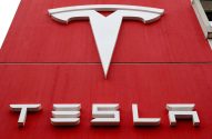 Logo branco da Tesla em letreiro vermelho.