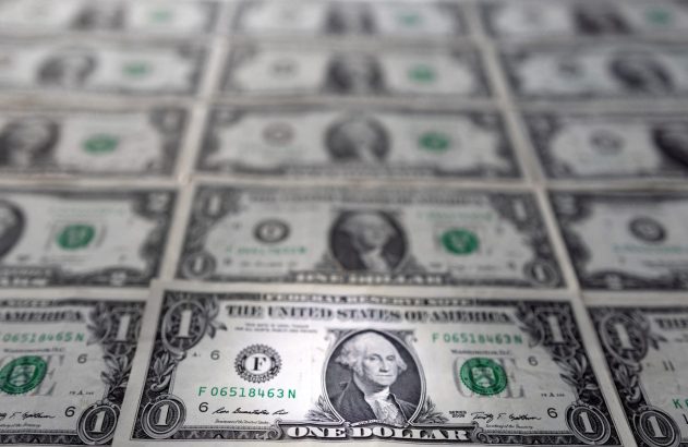 Cédulas de um dólar americano dispostas em grade, com foco nas da frente e as de trás borradas.