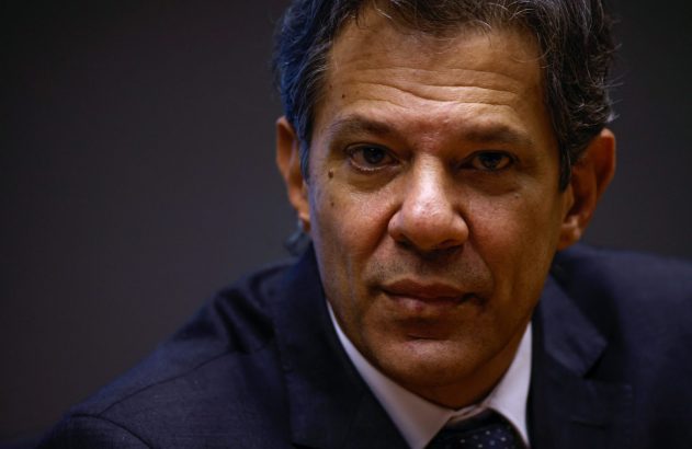 Retrato de um homem de meia-idade, com cabelos grisalhos, vestindo terno e gravata, olhando diretamente para a câmera.