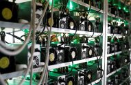 Racks com equipamentos eletrônicos em funcionamento, iluminados por luz verde.