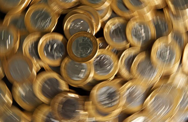 Muitas moedas douradas e prateadas girando rapidamente, criando um efeito de desfoque de movimento.